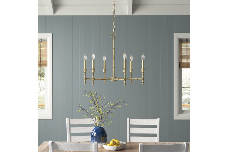 gold chandelier in a farmhouse dining room with blue shiplap walls