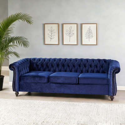 Luxueux canapé Chesterfield 3 places avec revêtement en velours, capitonnage à boutons et têtes de clou élégantes pour un style de salon intemporel.