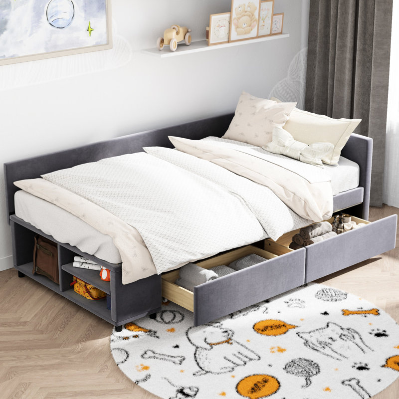 Lit simple tapissier en forme de L gris avec rangement. Revêtement en velours doux, tête de lit. Tiroirs pour la literie et les vêtements supplémentaires. Décoration latérale pour livres. Construisez une tête de lit confortable