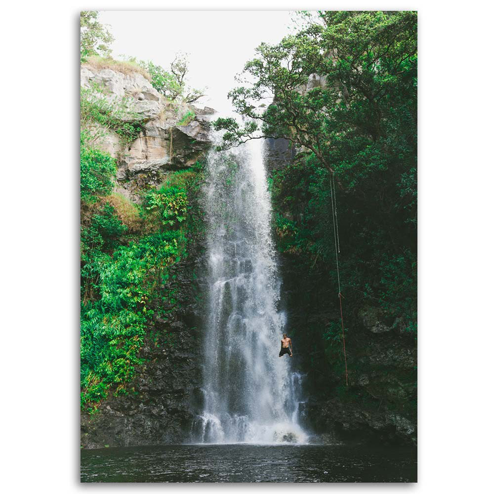 Leinwandbild Mann springt von einem Wasserfall