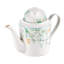 Théière en porcelaine et feuilles vertes