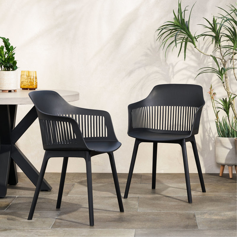 Chaises d'extérieur Dahlia. En polypropylène noir. Dimensions : 84 cm (H) x 57 cm (L) x 55 cm (P). Style minimaliste et confort.