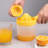 Manual Juicer Squeezes Lemon Separates Cup With Scale Holds Hand And Presses Juices-130490751