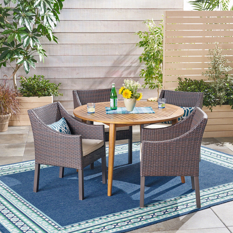 Gustel 4 - Person Acacia Wicker Patio Dining Set with Round Table , Cushions Included, Teak/Brown Frame / Beige Cushion