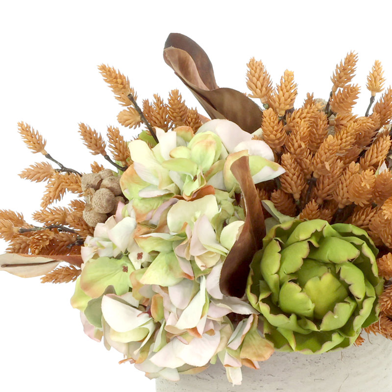 Centre de table d'automne avec hortensias, artichauts et pommes de pin