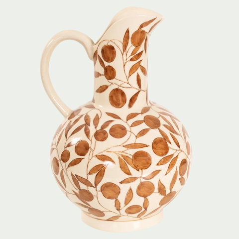 Cream-colored ceramic pitcher with a round base and painted brown olive branch motif.