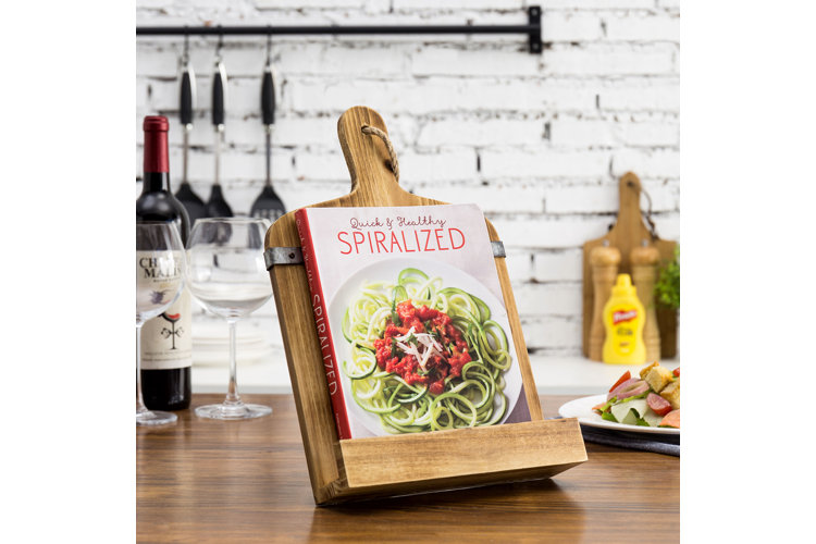 A wooden book stand used to display a recipe book on how to spiralize vegetables.