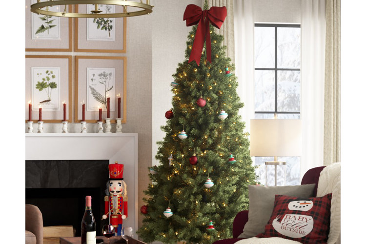 pre-lit christmas tree with a red bow as a tree-topper