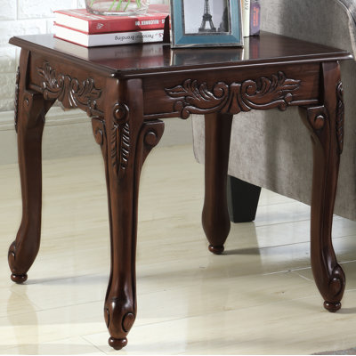 Longoria End Table Traditional Ornate Detailing Wood End Table Warm, rich colors and ornate detailing. Features detailed claw feet. Composed of wood and veneer, the end table is finished in elegant brown
