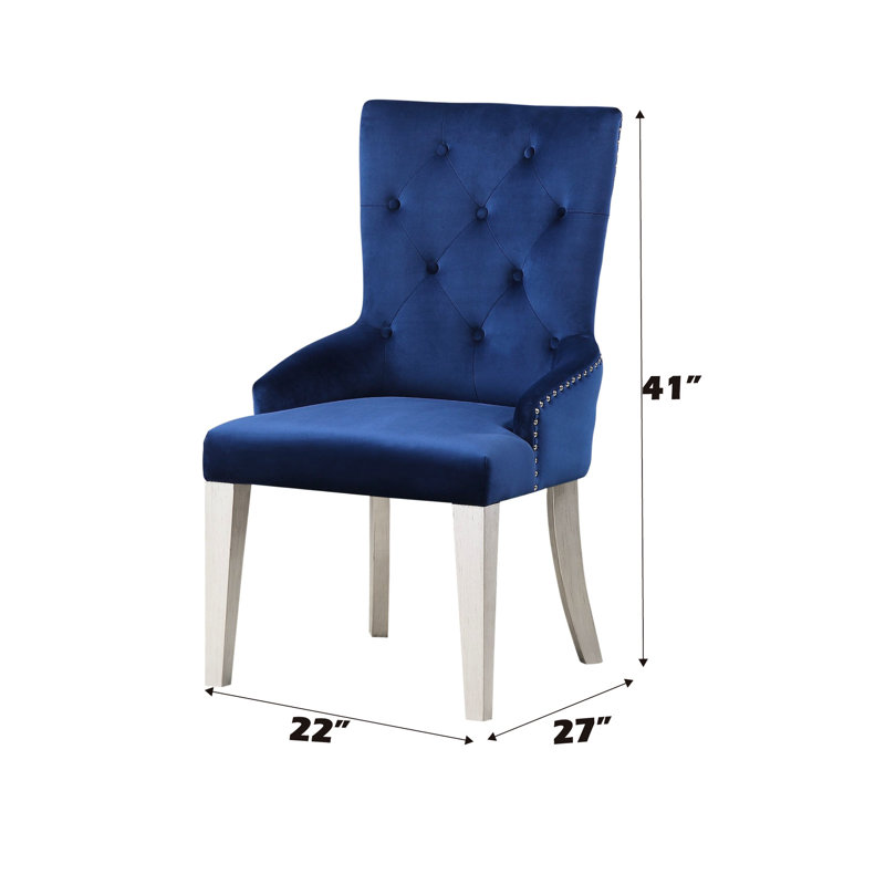 Fauteuil de salle à manger moderne en tissu bleu luxueux avec dossier capitonné et pieds fuselés en bois. Siège rembourré et tablier.