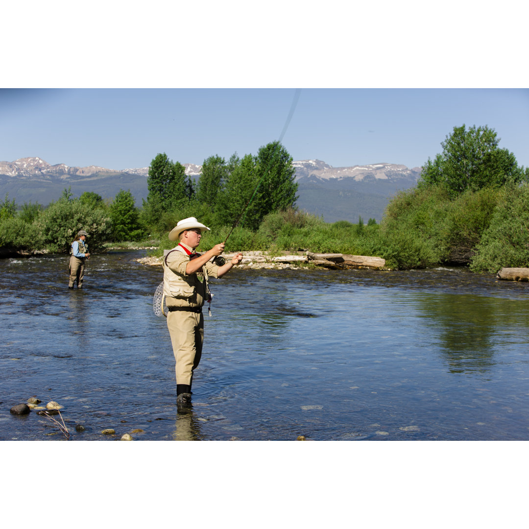 Sport: Pärchen beim Fliegenfischen im Fluss. Ausrüstung und Hut. Rocky Mountains. von Fstop123 - No Frame Set auf Leinwa...