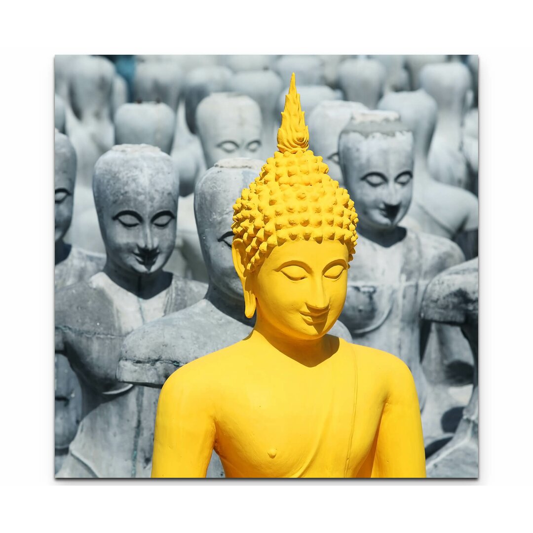 Leinwandbild Prächtige Buddhaskulptur zwischen grauen Statuen