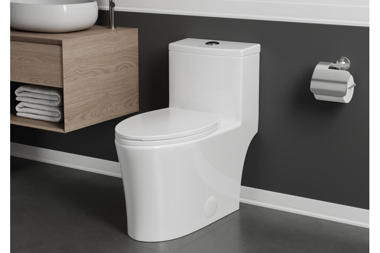 Bathroom with a white elongated toilet beside a wood floating vanity.