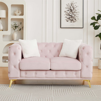 Ce canapé en velours de luxe moderne de 61,25 pouces avec capitonnage à boutons Chesterfield et pieds en métal comprend deux coussins décoratifs.
