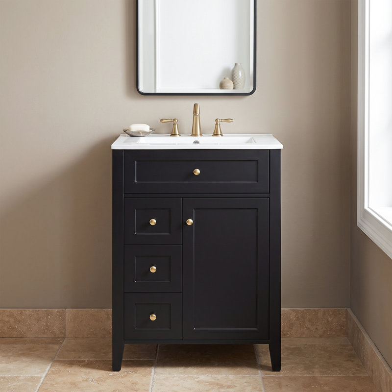 Meuble-lavabo autoportant en MDF noir de 61 cm (24 po) avec lavabo en céramique, poignées en métal, porte à fermeture amortie et tablette de rangement.