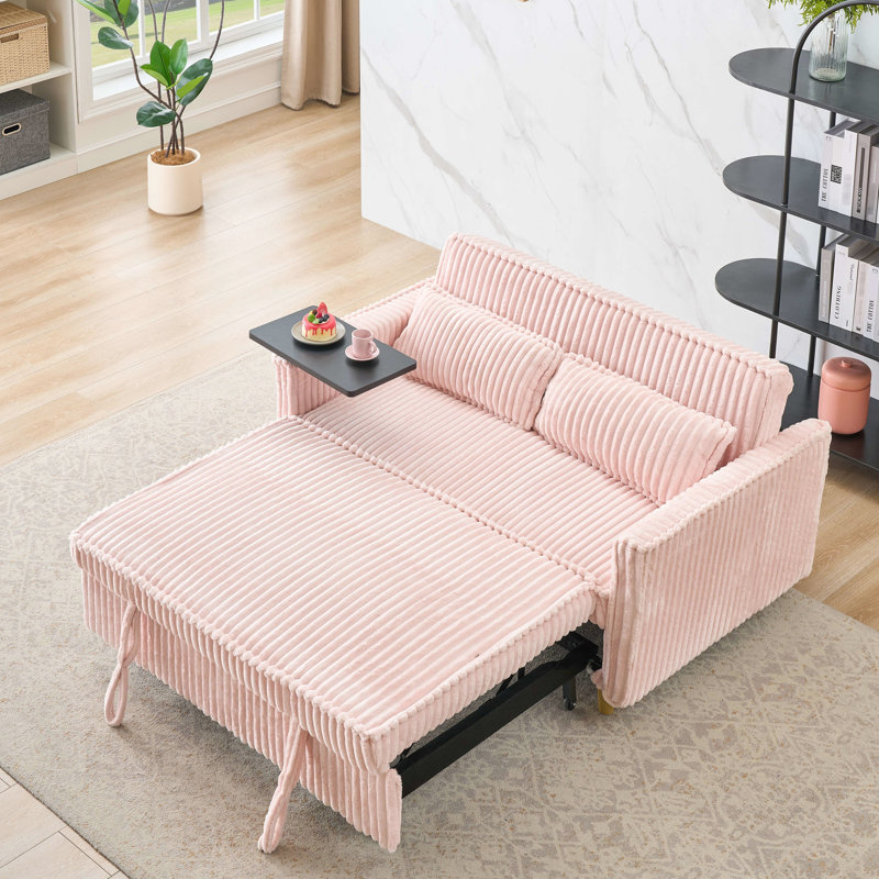Velours côtelé rose avec des ajouts novateurs : lit gigogne, table basse amovible, ports pour une expérience inédite. Élégant : ports, se transforme en lit luxueux.