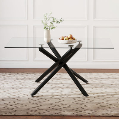 Table de salle à manger en verre avec surface trempée et structure en métal noir, pouvant accueillir 4 à 6 personnes dans une cuisine ou une pièce avec pieds contemporains, jusqu'à