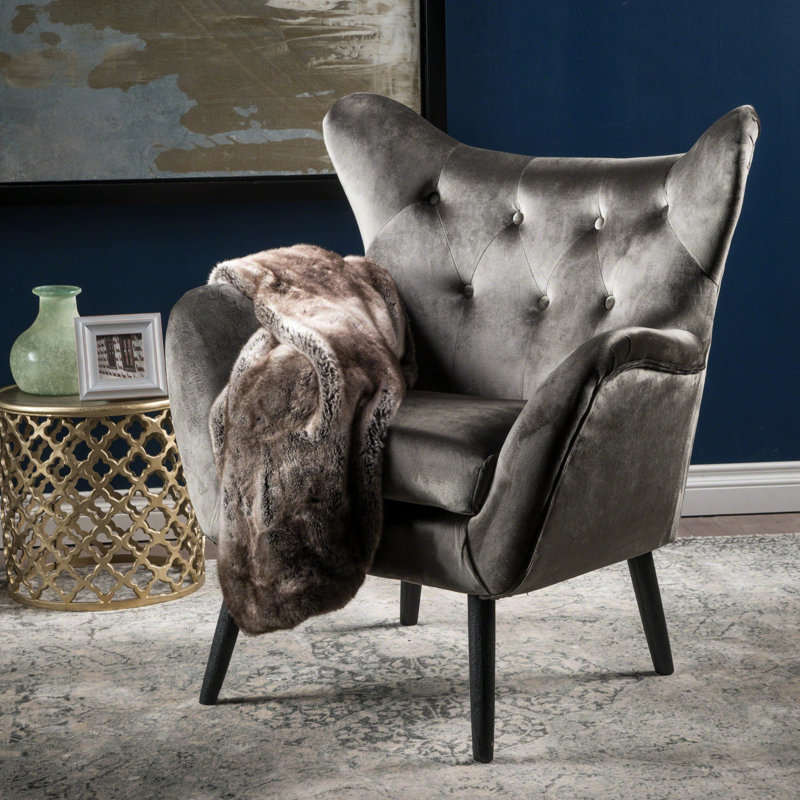 Le fauteuil en velours gris, le cadre et le dossier à oreilles allient style et fonctionnalité, Gris