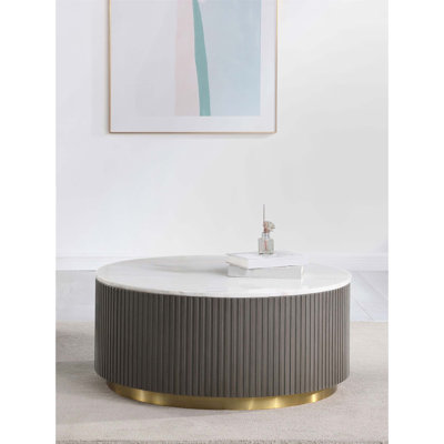 Table basse ronde à plateau en marbre avec base côtelée gris anthracite et pieds en métal doré brossé, parfaite pour les espaces modernes et transitionnels.