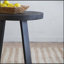 Table basse élégante et fonctionnelle avec surface arrondie et structure moderne à pieds croisés