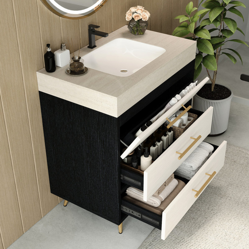 Meuble-lavabo sur pied contemporain avec lavabo en céramique intégré et surface en pierre frittée. Ce meuble-lavabo offre un support stable avec ses pieds en acier thermolaqué et ses poignées encastrées dorées. L'évier a un grand