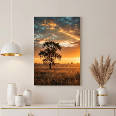 Art mural en forme de silhouettes d'arbres sous un coucher de soleil doré