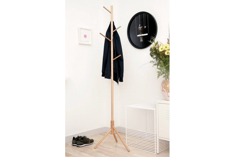 A modern wooden oak coat rack holding a coat.