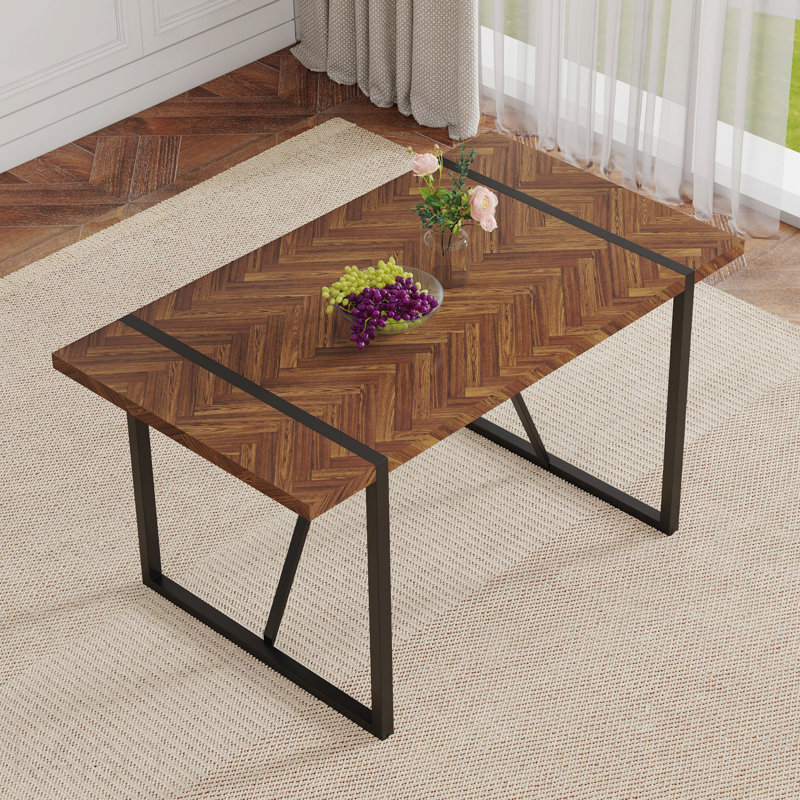 Une table de salle à manger rectangulaire rétro minimaliste avec un dessus spécialement texturé et des pieds en métal noir.