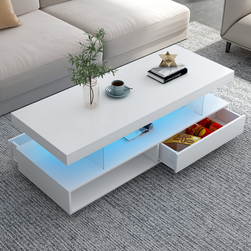 Table centrale à DEL blanche avec tiroirs: 2 espaces de rangement, 16 lumières colorées, 6 niveaux de luminosité et une surface de rangement pour le café dans le salon: blanc. , Luminosité variable. Tiroirs spacieux et tablettes de présentation.
