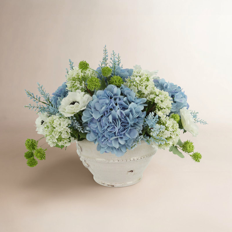 Hortensias, viburnum et astilbe disposés dans un vase en céramique