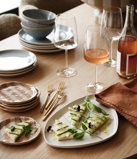 Close-up of rose wine with appetizers and dishes on a table.