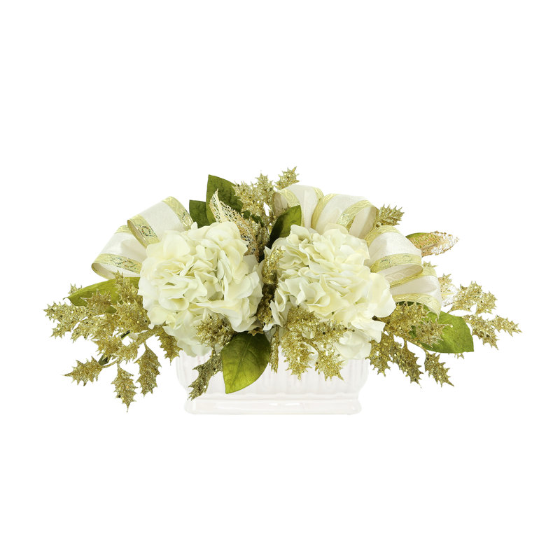 Arrangement d'hortensias avec houx scintillant et boucles dans un vase