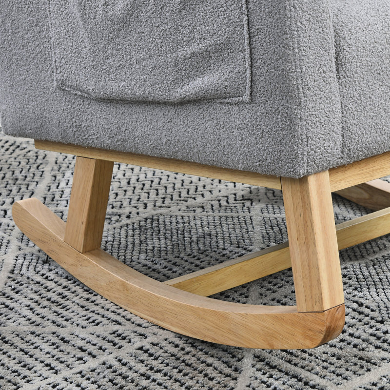 Fauteuil à bascule de salon moderne à dossier haut avec un coussin lombaire, deux poches latérales et un ours en peluche.