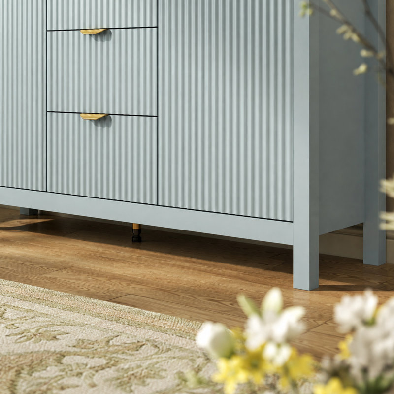 Buffet Varello 47,2 po au design moderne ondulé, avec 3 tiroirs, un placard à double porte, une étagère réglable à 3 niveaux, des poignées en aluminium et un système de rangement à fermeture amortie.