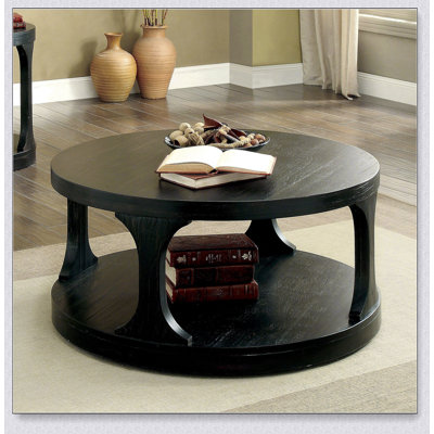 Table basse ronde de style transitionnel au fini noir antique avec tablette de rangement supplémentaire et pieds au design complexe