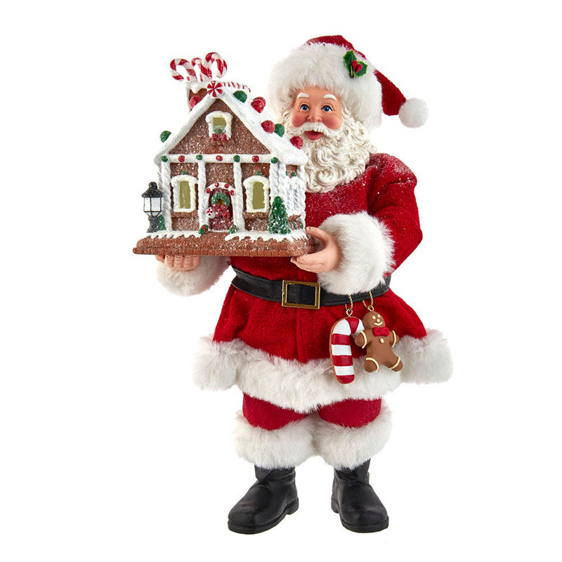 Père Noël avec maison de pain d'épices illuminée