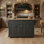 Grand îlot de cuisine en bois d'hévéa noir avec comptoir pliant à texture en relief. Mouvement à quatre roues, plusieurs portes et tiroirs pour un rangement maximal.
