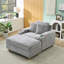 Canapé simple en velours côtelé gris avec un coussin, deux coussins décoratifs, un repose-pieds et deux espaces de rangement.