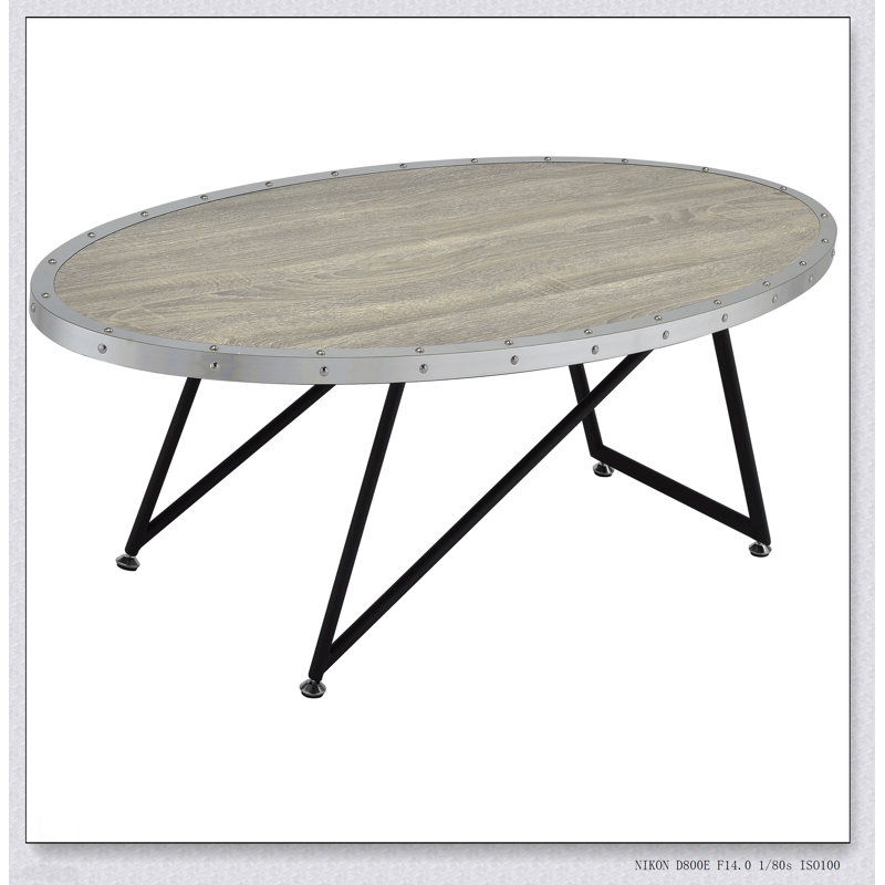 Table basse ovale en chêne gris patiné et noir, alliant charme industriel et élégance moderne pour des espaces de vie élégants.