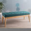 Élégant banc bleu sarcelle, revêtu d'un tissu de qualité et d'une structure texturée en bois de bouleau