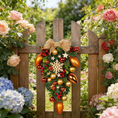Couronne de Noël festive en forme de goutte avec ornements or et orange, baies rouges et nœud en toile de jute
