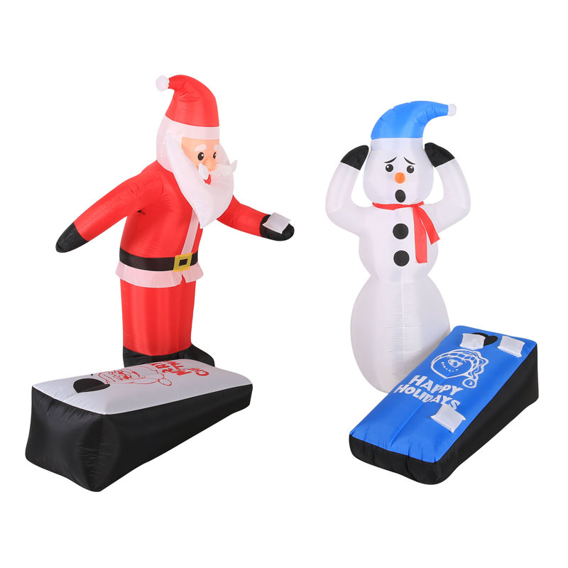 Père Noël et bonhomme de neige jouant au jeu de cornhole gonflable