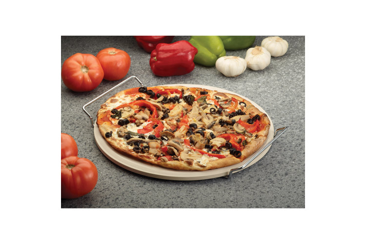 vegetable pizza on clay pizza stone on granite countertop