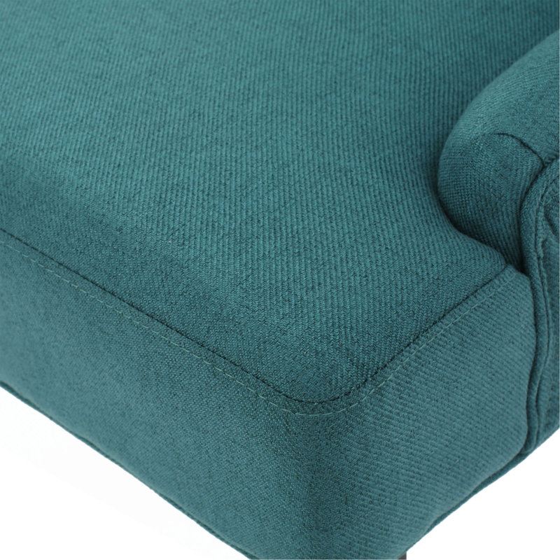 Luxueux fauteuil rembourré en velours avec dossier capitonné et structure en bois robuste, pour ajouter une touche d'élégance à tout espace de vie.