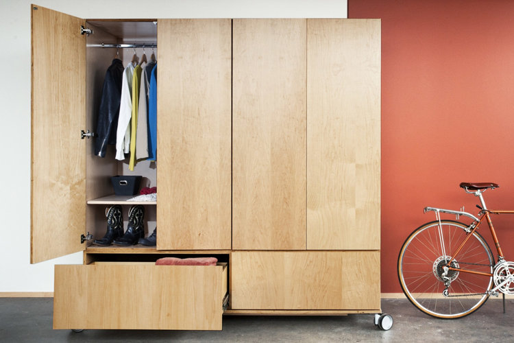 Large rolling oak storage closet with one open door and drawer.