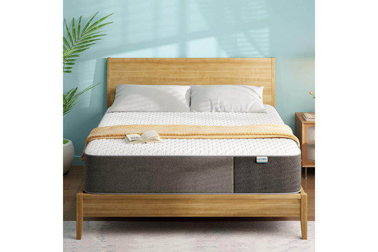 white memory foam mattress on a wood bed frame against a blue feature wall