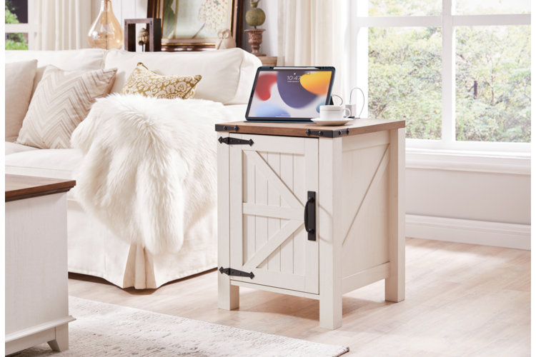 a white farmhouse style end table with a wood top and a cabinet