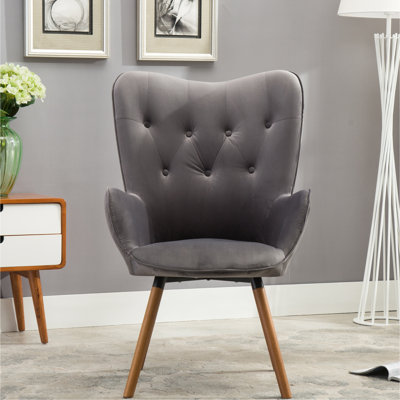 Fauteuil gris à dossier capitonné avec pieds en bois fermes, capitonnage élégant et structure robuste