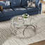 Table basse moderne avec plateau rond en verre et structure circulaire en métal-133089138