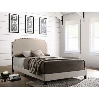 Grand lit à panneau beige avec surface de couchage confortable et garniture cloutée pour un sommeil de qualité